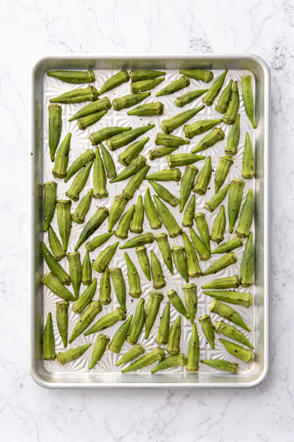 Okra on a baking sheet before baking.
