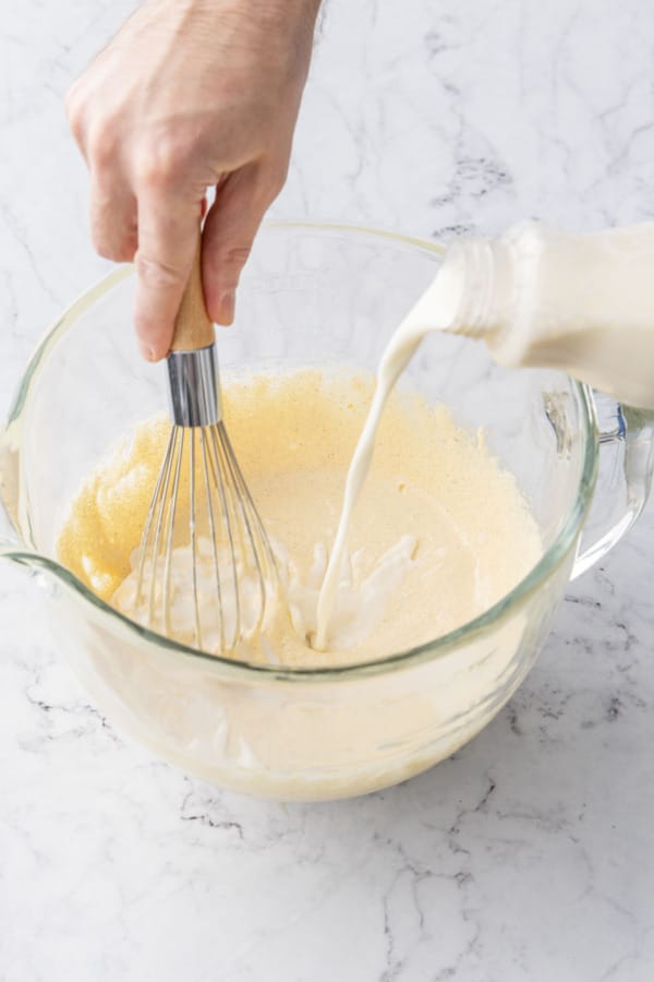 Slowly pouring in dairy and whisking until smooth and incorporated.