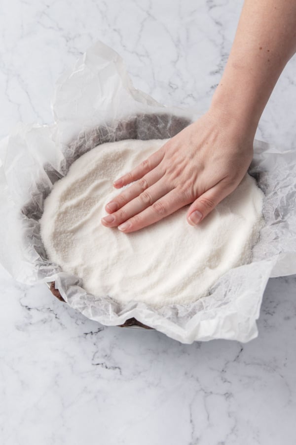 Filling the lined crust to the very top to prevent slumping.