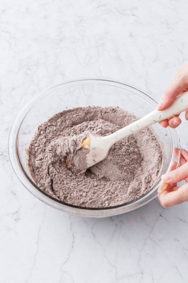 Gently mixing dry ingredients with a silicone spatula until no streaks of dry flour remain.
