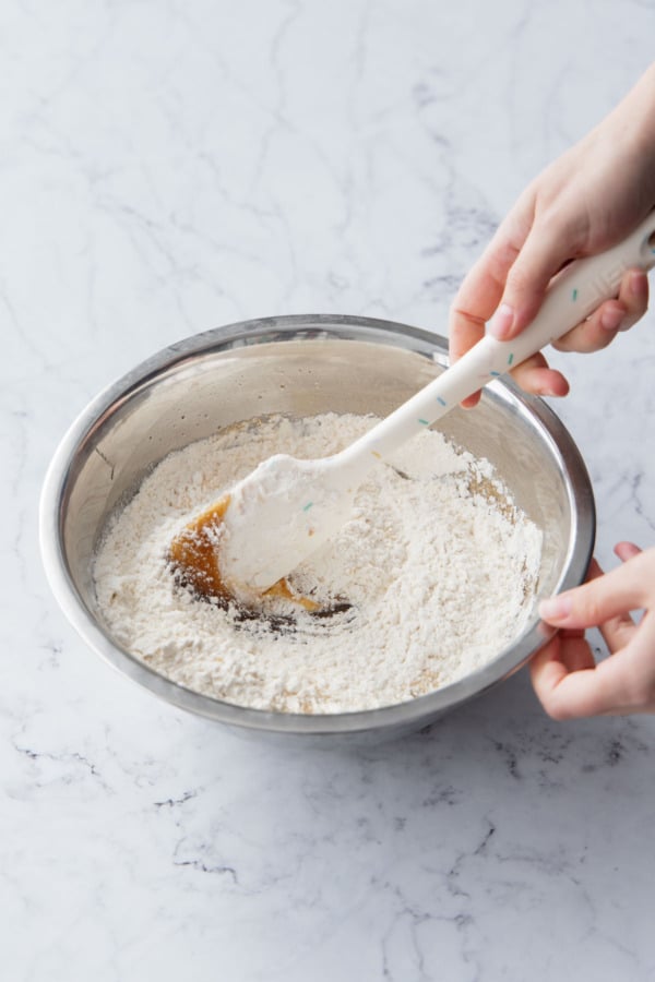 Stirring in the dry flour with a rubber spatula.